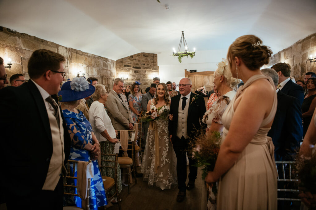 Bride and her father walking down the aisle at Danby Castle
