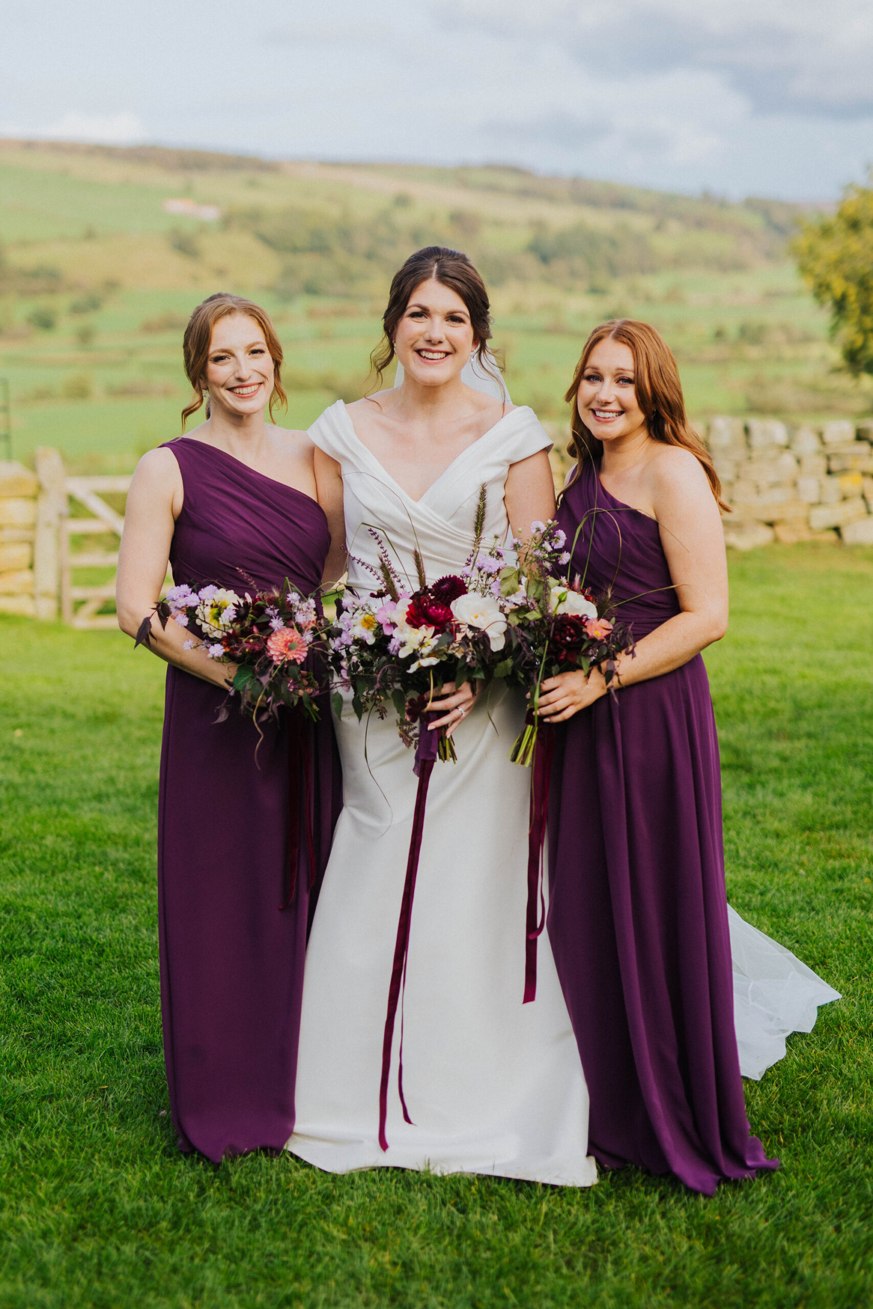 Bridesmaids in purple, claret wedding dress. . Moonwind Flowers.
